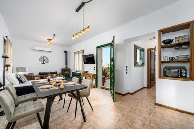 a dining room and living room with a table and chairs at Moana House in Sálakos