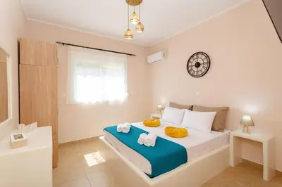 a bedroom with a large bed with towels on it at Sunny View Retreat House in Archangelos