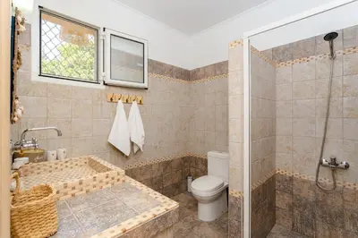a bathroom with a tub and a toilet and a window at Sunny View Retreat House in Archangelos