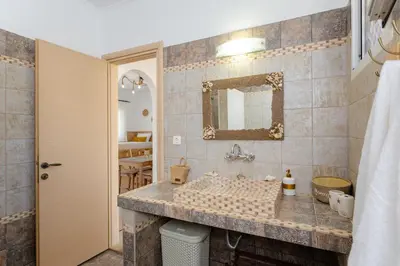 a bathroom with a sink and a mirror at Sunny View Retreat House in Archangelos
