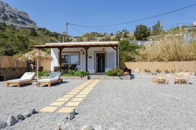 a house on the beach with chairs and a porch at Sunny View Retreat House in Archangelos