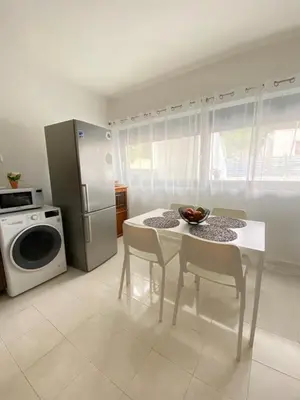 a kitchen with a white table and a refrigerator at Magio House in Ixia