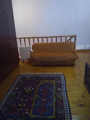 a couch in a living room with a rug on the floor at House of dreams in Rhodes Town