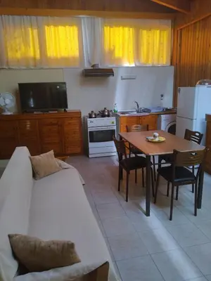 a living room with a table and a kitchen with a white couch at House of dreams in Rhodes Town