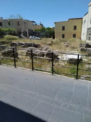 a fence next to a sidewalk next to a building at House of dreams in Rhodes Town