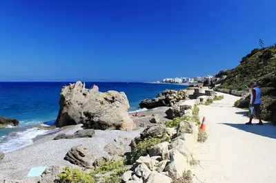 a man standing on a beach next to the ocean at Knights Golden Loch - Rhodes Unique Getaway in Rhodes Town