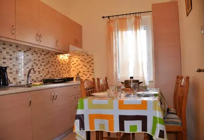 a kitchen with a table with a table cloth on it at Georgias Apartments in Haraki