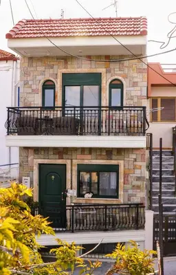a building with a green door and a balcony at La Casa Di Silvia in Apolakkiá