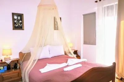a bedroom with a bed with a mosquito net at La Casa Di Silvia in Apolakkiá