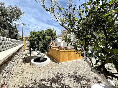 a garden with two trees and a fence at Casa Piaduli in Faliraki