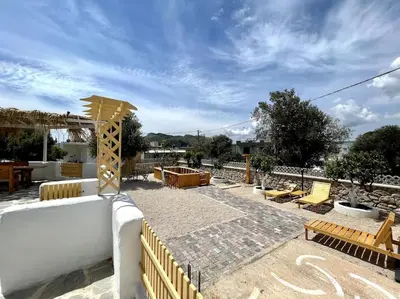 a patio with benches and tables and a fence at Casa Piaduli in Faliraki