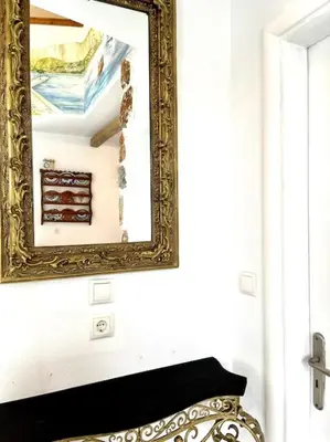 an ornate mirror on a wall above a bench at Casa Piaduli in Faliraki