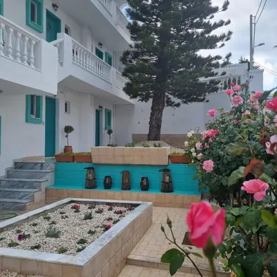 a garden in front of a building with flowers at Arocaria - Faliraki peaceful apartments in Faliraki
