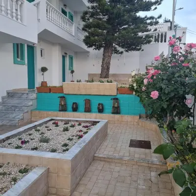 a garden in front of a house with flowers at Arocaria - Faliraki peaceful apartments in Faliraki