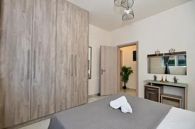 a bedroom with a bed and a large wooden cabinet at Harmony Seaside House in Ialyssos
