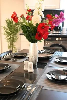 a table with a vase filled with red and white flowers at Harmony Seaside House in Ialyssos