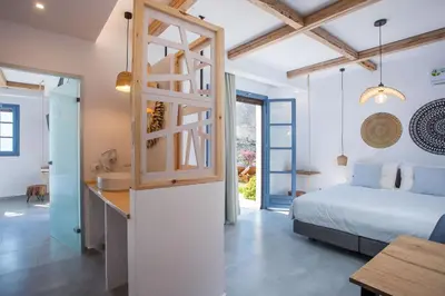 a bedroom with a bed and a bathroom with a sink at THALASSA in Livadia