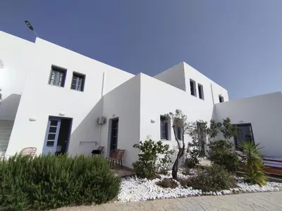 a white house with black doors and windows at THALASSA in Livadia