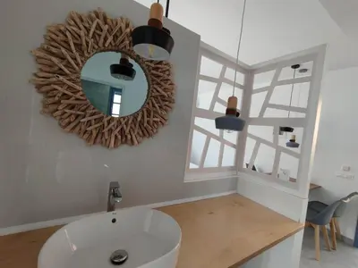 a bathroom with a mirror and a sink at THALASSA in Livadia