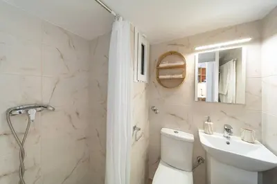 a bathroom with a toilet and a sink and a shower at Urban Escape in Rhodes Town