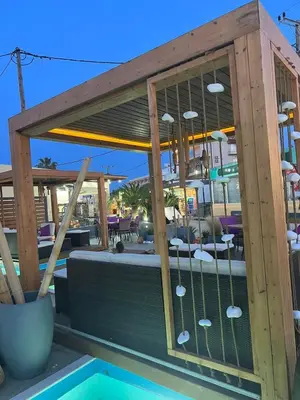 a patio with a table and a swimming pool at Faliro Hotel in Faliraki