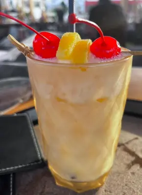 a drink with oranges and cherries on a table at Faliro Hotel in Faliraki