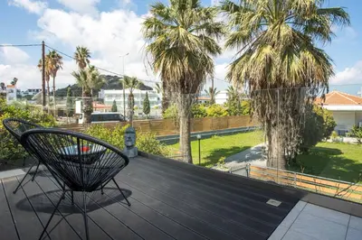 a deck with a chair and palm trees at Faliro Hotel in Faliraki