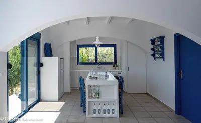 a kitchen with an archway with a counter and a refrigerator at Evelia Sea House in Plimmiri