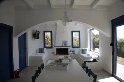 a living room with white furniture and windows at Evelia Sea House in Plimmiri