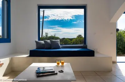 a room with a large window with a couch and a table at Evelia Sea House in Plimmiri