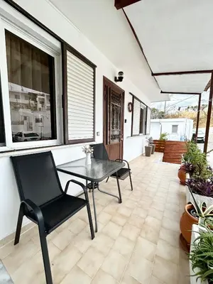 a patio with a table and a black chair at Philoxenia House in Asklipio in Asklipiḯon