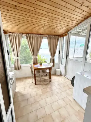 a dining room with a table and some windows at Philoxenia House in Asklipio in Asklipiḯon