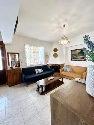 a living room with a blue couch and a table at Philoxenia House in Asklipio in Asklipiḯon