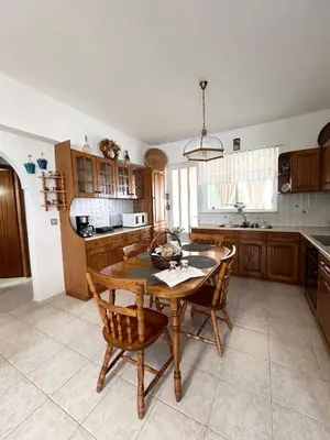 a kitchen with a wooden table and chairs and a table at Philoxenia House in Asklipio in Asklipiḯon