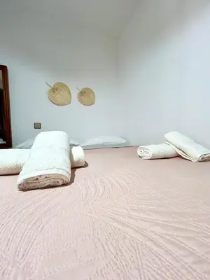 a bed with white blankets and hats on the wall at Philoxenia House in Asklipio in Asklipiḯon