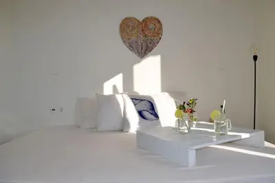 a white bedroom with a white bed and a table at Elektra Apartment-Kallithea in Kallithea Rhodes