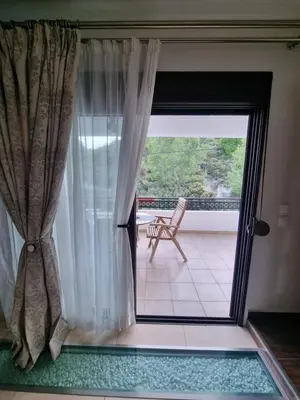 a room with a window and a chair on a balcony at Precious Emma's House in Afantou