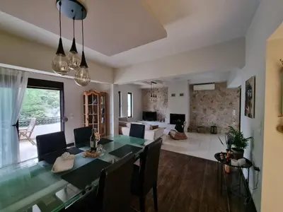 a dining room and living room with a table and chairs at Precious Emma's House in Afantou