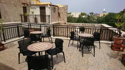 a patio with tables and chairs on a balcony at Eleni Rooms in Rhodes Town