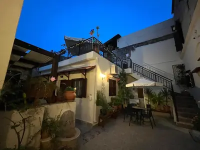 a building with a balcony and a table and chairs at Eleni Rooms in Rhodes Town
