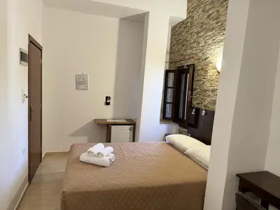 a bedroom with a bed with two towels on it at Eleni Rooms in Rhodes Town