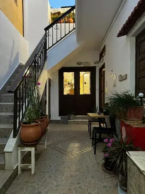 a hallway with potted plants and a staircase at Eleni Rooms in Rhodes Town