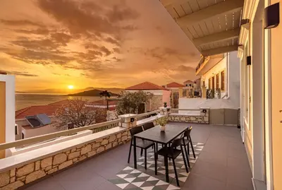 a balcony with a table and a view of the ocean at Chalki Sunrise Suites in Halki