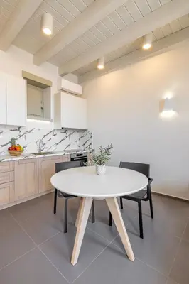 a kitchen with a table and chairs in a room at Chalki Sunrise Suites in Halki