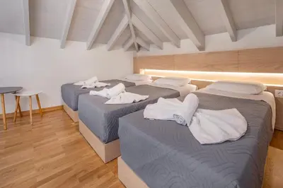 a group of three beds in a room at Chalki Sunrise Suites in Halki