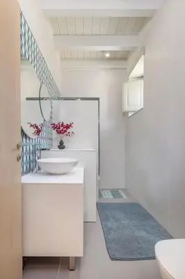 a white bathroom with a sink and a toilet at Chalki Sunrise Suites in Halki