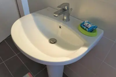 a white sink in a bathroom with a toothbrush at Greek stories by evaGstays in Faliraki