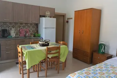 a kitchen with a table and chairs and a refrigerator at Greek stories by evaGstays in Faliraki