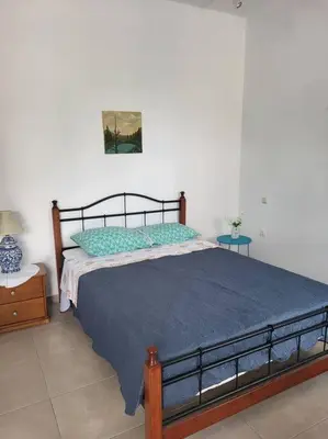 a bedroom with a large bed with a blue blanket at Greek stories by evaGstays in Faliraki
