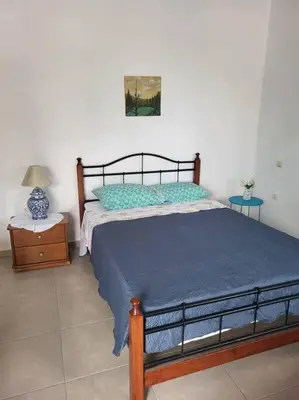 a bedroom with a bed with a blue comforter at Greek stories by evaGstays in Faliraki